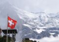 Montagne sicure montagne imbiancate dalla neve e bandiera svizzera