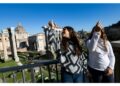 Dalla terrazza sul Campidoglio il gesto d'auspicio dei turisti