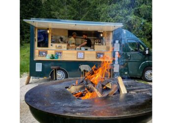 Furgoncini itineranti con cucina-barbeque davanti alle montagne