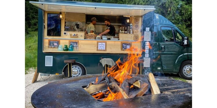 Furgoncini itineranti con cucina-barbeque davanti alle montagne