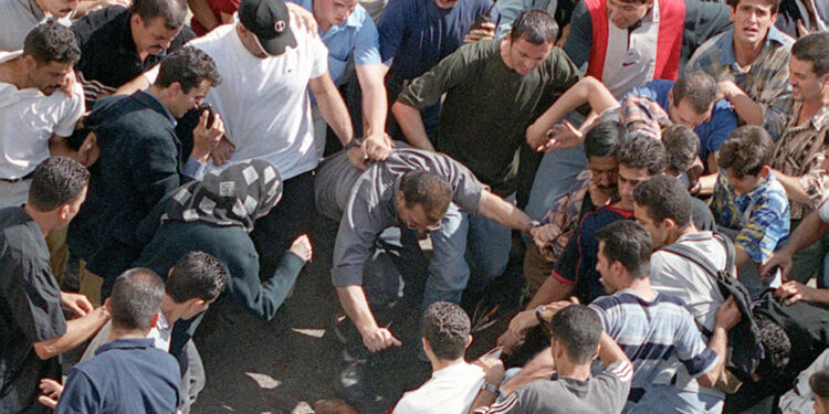 Aziz Salha fotografato mentre agitava le mani sporche di sangue