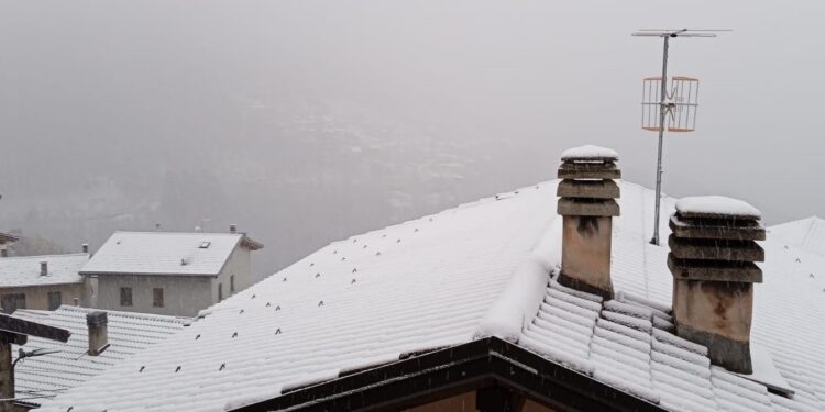 La neve sui tetti di San Bartolomeo Val Cavargna. Sullo sfondo, l'abitato di Cusino