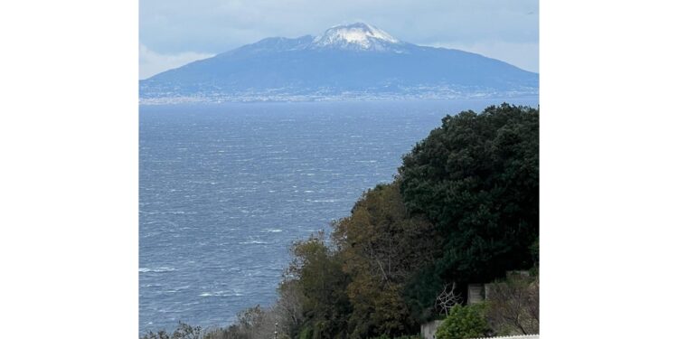 Dalla piazzetta dell'isola l'immagine del vulcano imbiancato