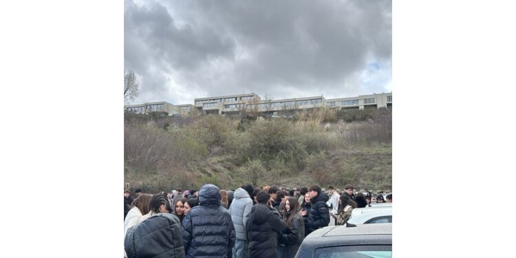 Molte persone in strada. Gli studenti lasciano gli istituti